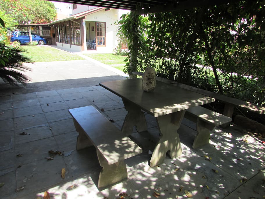 Carramanchão do jardim com mesa e bancos de pedra