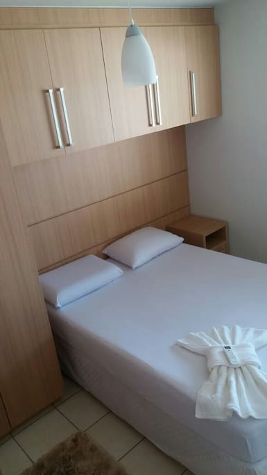 Quarto com ar condicionado, roupas de cama mesa e banho.