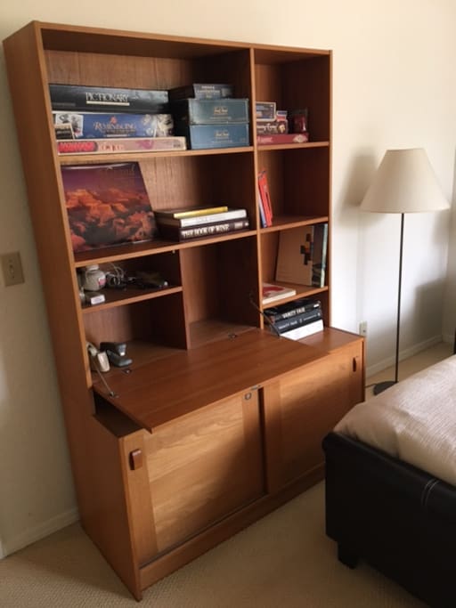 The shelving unit by your bed has a fold-out desk, board games, local trail guides and fun books