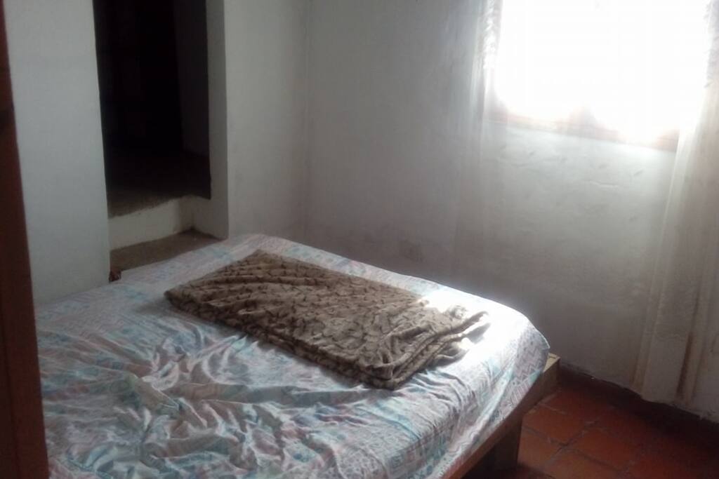 Dormitorio con cama matrimonial y vista al mar.