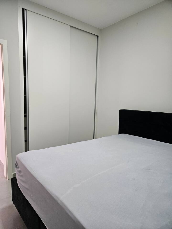 חדר עם מיטת קווין סייז, מלתחה ומאוורר