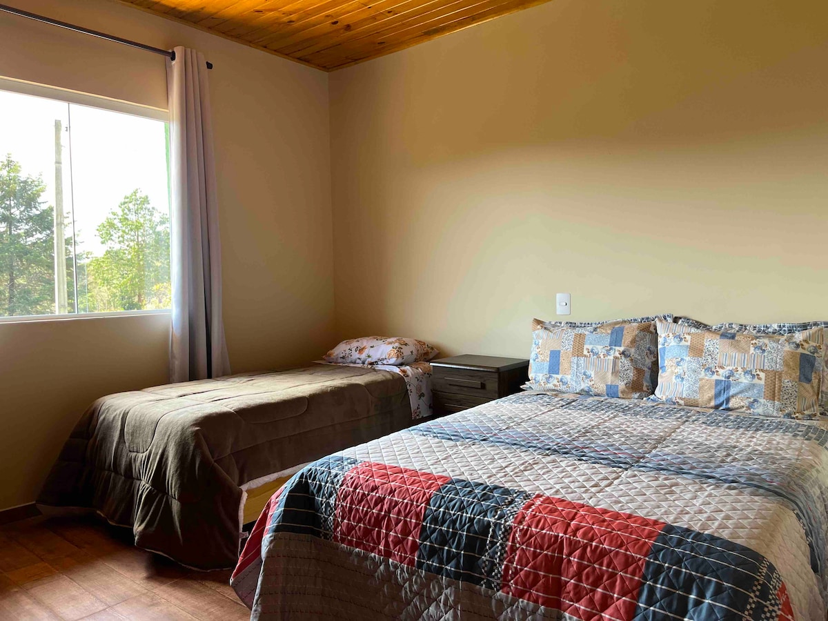 Slaapkamer 3: Suite, met een tweepersoonsbed, een eenpersoonsbed, een dressoir en een 43-inch tv met open zenders. 