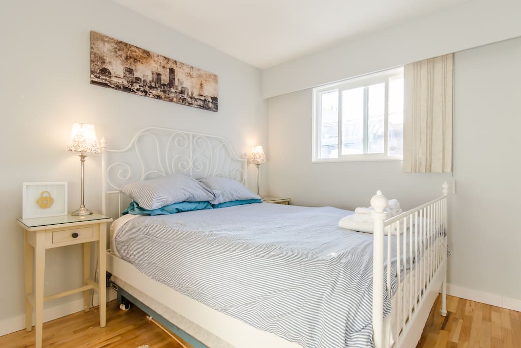 Bedroom with queen size bed next to the washroom, also has a closet.