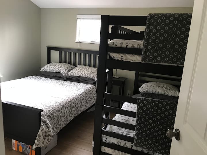 Habitación familiar en la planta superior con una cama tamaño queen y una litera doble.