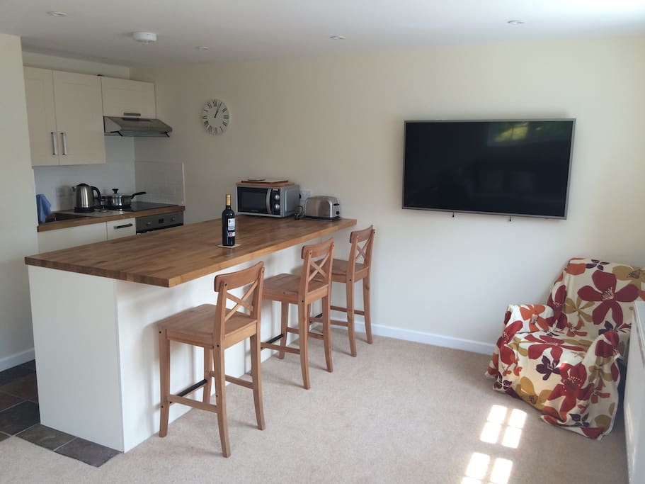 View of the kitchen area/ breakfast bar and large HD TV