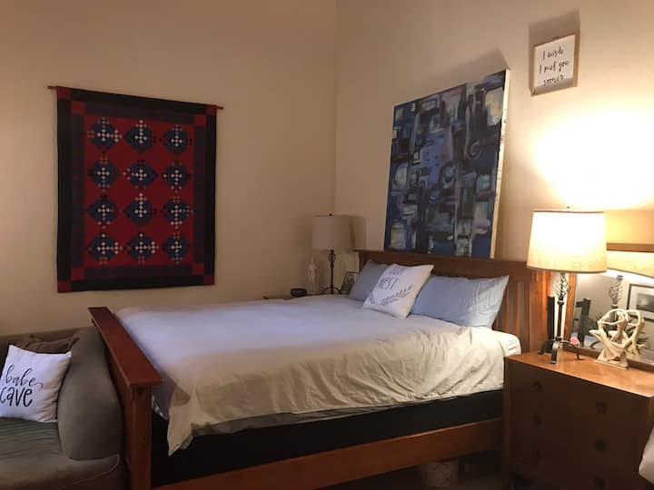 Las habitaciones están arriba. Este es el dormitorio principal con cama tamaño King. Llamamos a la Ponderosa. También tiene una sala de estar con dos giros y un baño privado completo con dos lavabos, ducha, inodoro y bañera.
