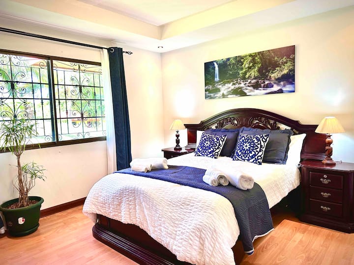 Guest House Bedroom #1 with a queen bed and smart TV.