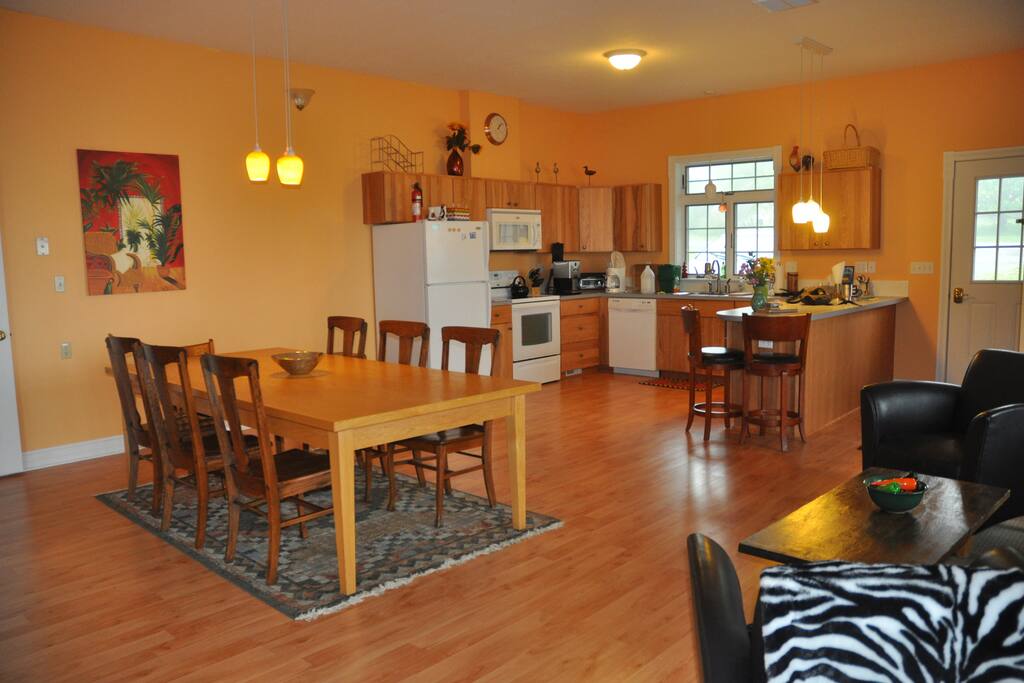 Large kitchen table and full kitchen with all utensils and cooking supplies.