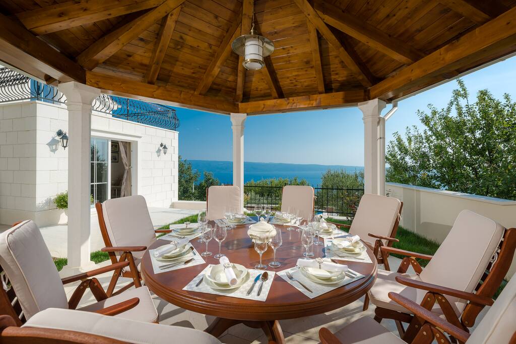 Outdoor dining area with barbecue all in living room and kitchen level (west)
