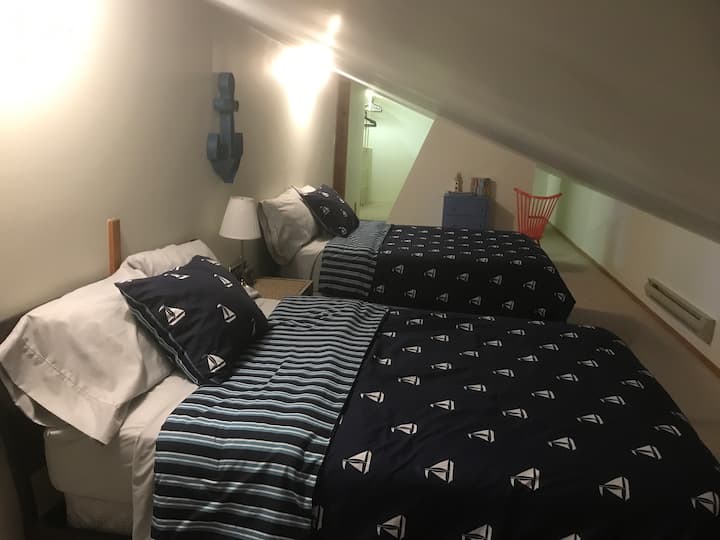 Dhoma e parë e gjumit me 2 krevate dopio në anën e majtë të dhomës së argëtimit të loftit  