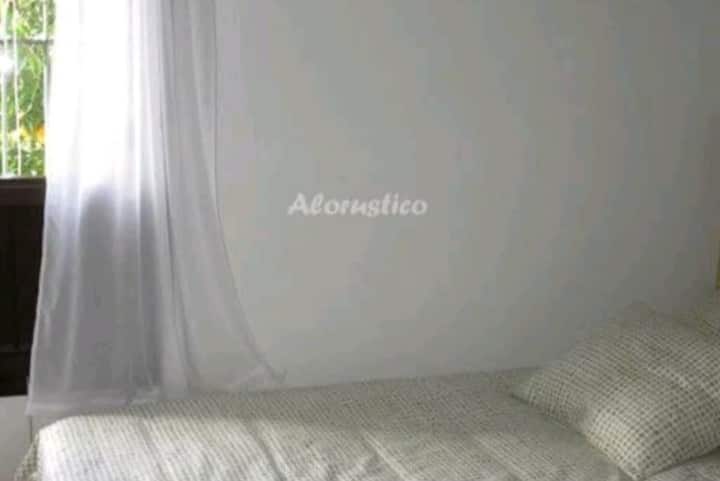 غرفة نوم واحدة مع سرير متحرك تحته للأطفال.