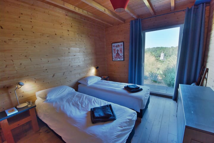 Begane grond tweede slaapkamer met tweepersoonsbed. Uitzicht op zee en de vallei en toegang tot het tuinterras. Met optie voor een tweepersoonsbed.