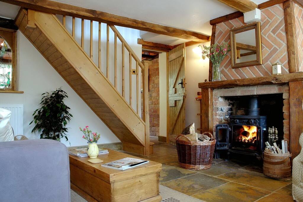 Lounge with log burning fire and sofa bed. Stairs lead up to galleried bedroom.