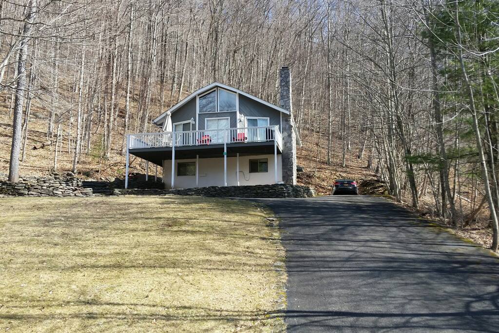 House on hill with wraparound porch.