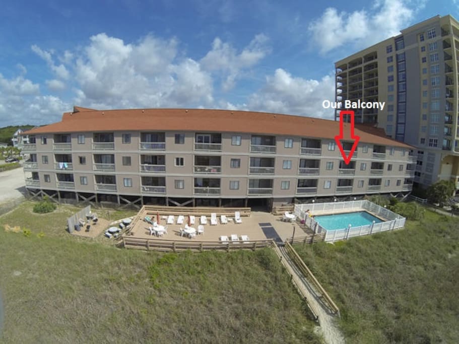 The complex showing our unit over the pool, great sundeck, charcoal grills and walkway to the beach