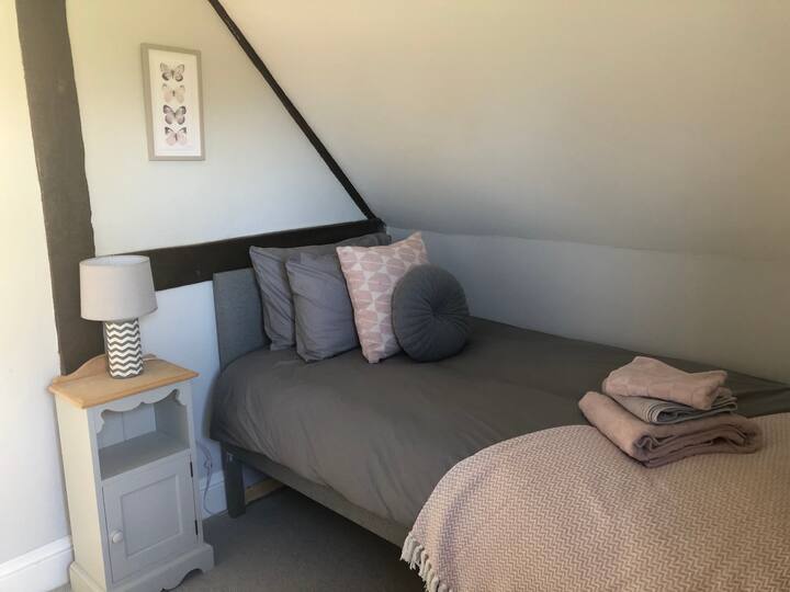 Cette chambre dispose de 2 lits simples. L'un est légèrement plus court car il se place sous le lit simple principal, donc si vous êtes très grand, cela pourrait être difficile.  Armoire intégrée dans la chambre et commode sur le palier.