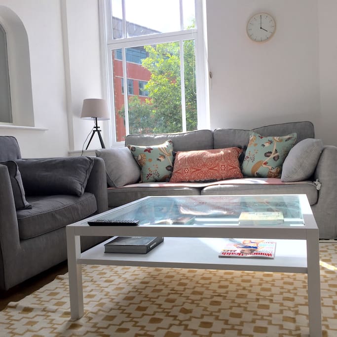 Bright and spacious living area with high ceilings and views on the canal outside