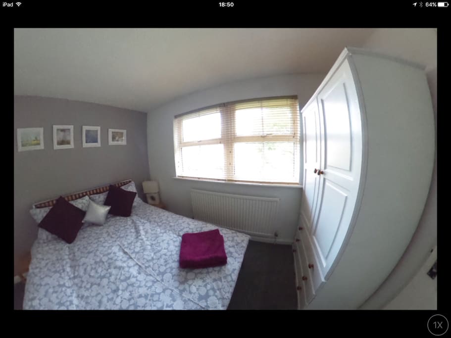 Wooden blinds to south west facing window to quiet private garden. Wardrobe with drawers.