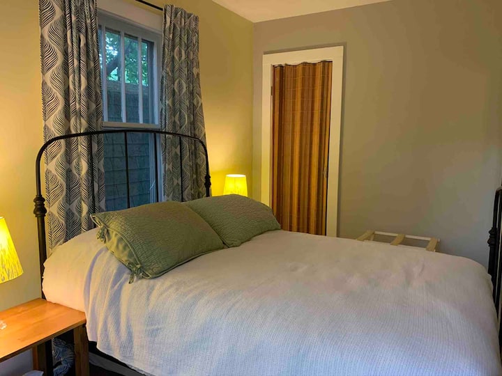 Julie’s room is on the first floor. It has a full sized bed, a window air conditioner, a ceiling fan, a closet, and glass sliding doors onto the deck (with floor length room darkening curtains if you’d rather have privacy than a view)
