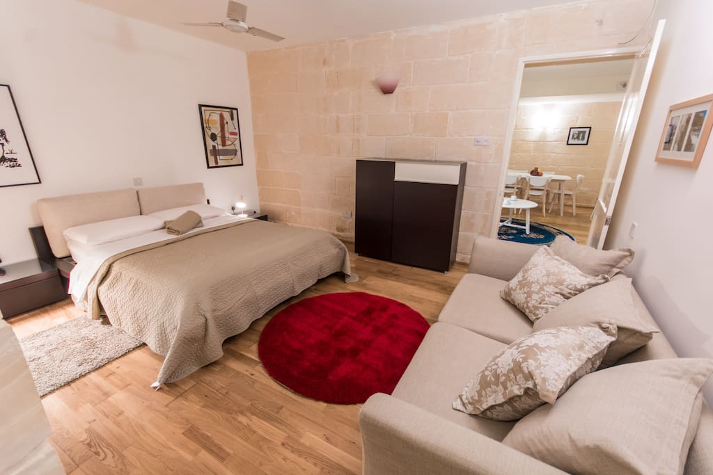 Main bedroom with double bed and couch.