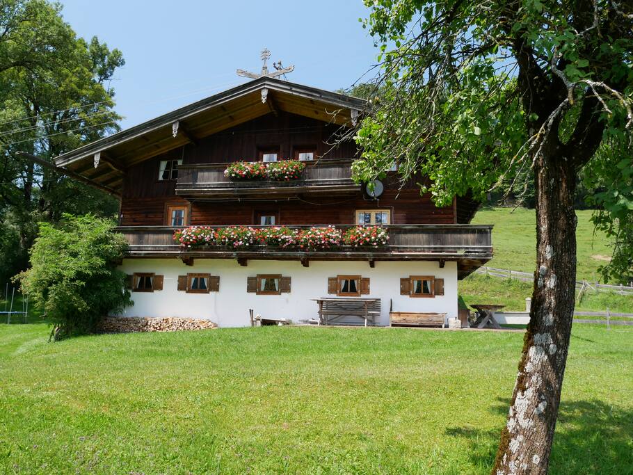 die Vorderansicht mit großem Garten und umliegenden Wiesen