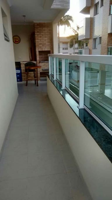 Varanda gourmet ao redor do apto com churrasqueira e forno a lenha.