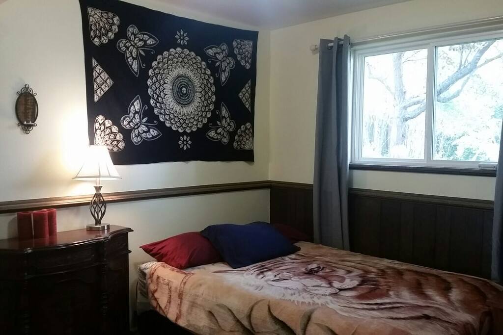 Downstairs bedroom with view of the backyard and green space. It now has a queen bed.