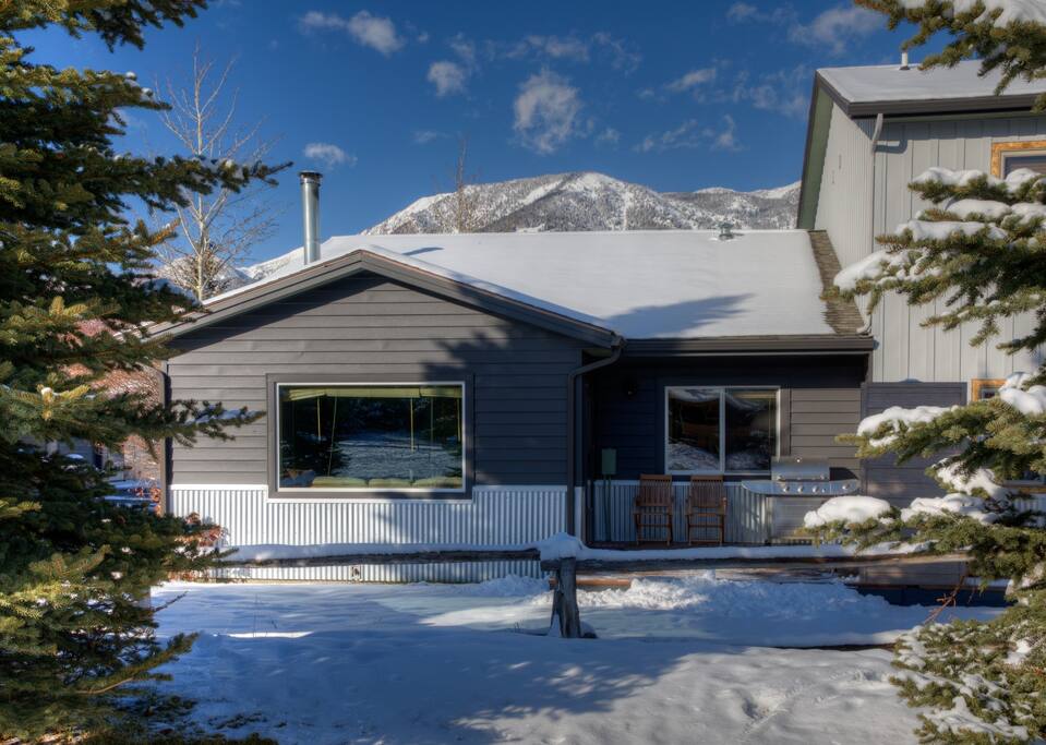 Back of corner unit condo borders a park with mountain views.