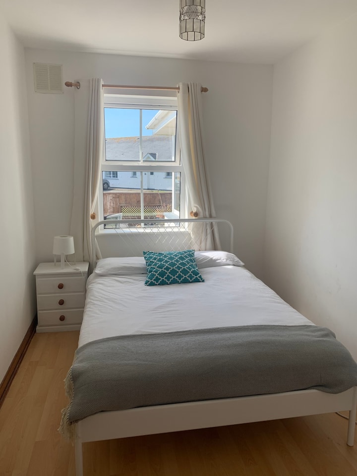 Chambre double avec tiroirs et table de chevet, donnant sur la terrasse