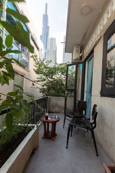 The balcony is covered by trees and flowers, looking straight to Landmark 81.