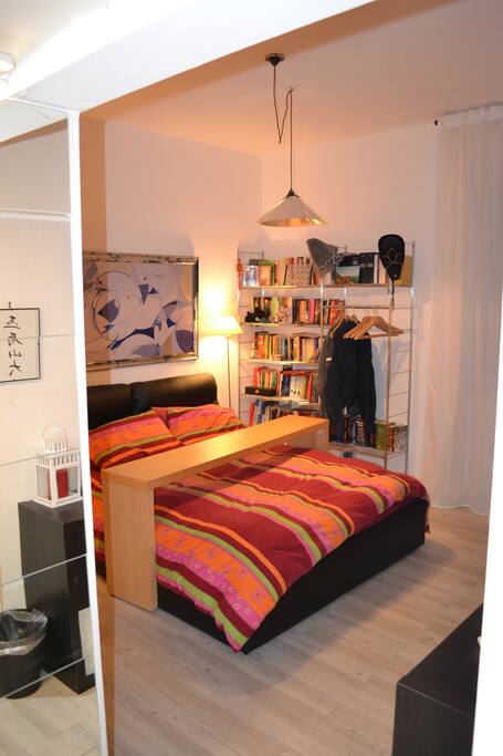 letto imbottito con tavolo mobile e ampia selezione di libri di narrativa di genere misto