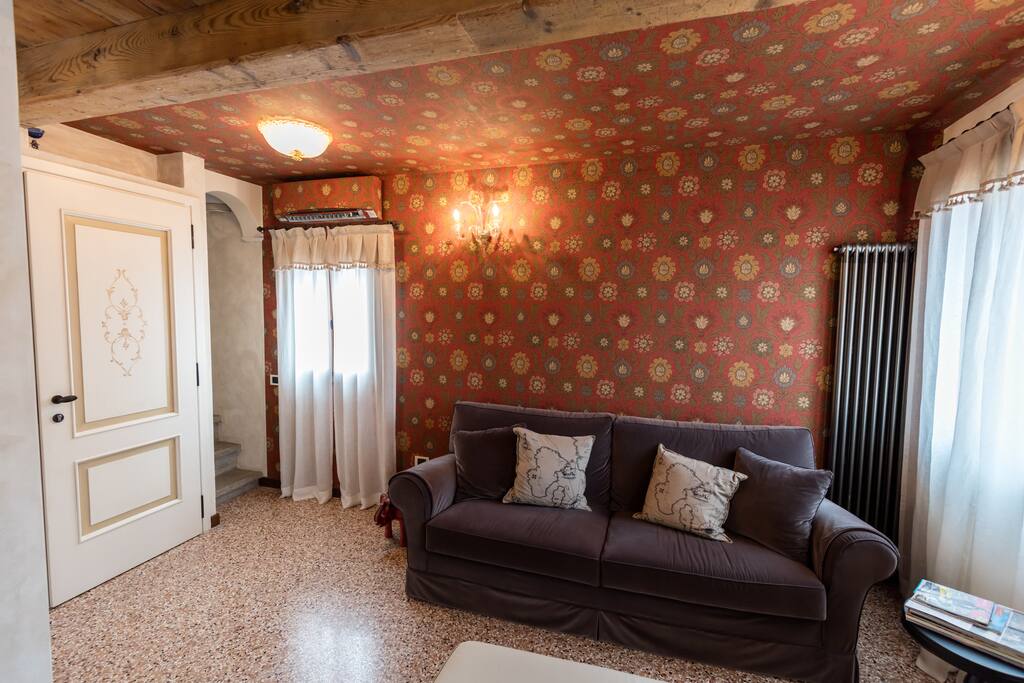 The living room and its decorative three-colour wallpaper.