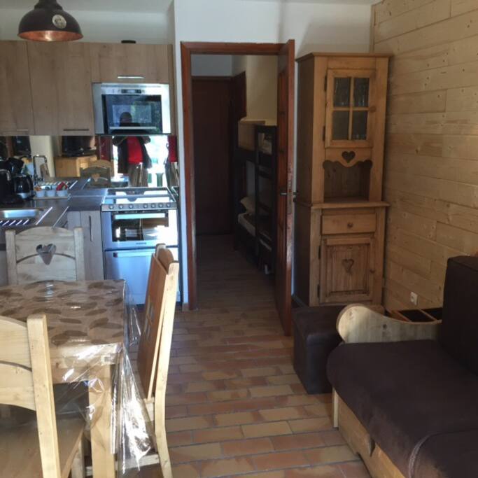 Vue d'ensemble,cuisine, et les deux lits superposés dans l'entrée .