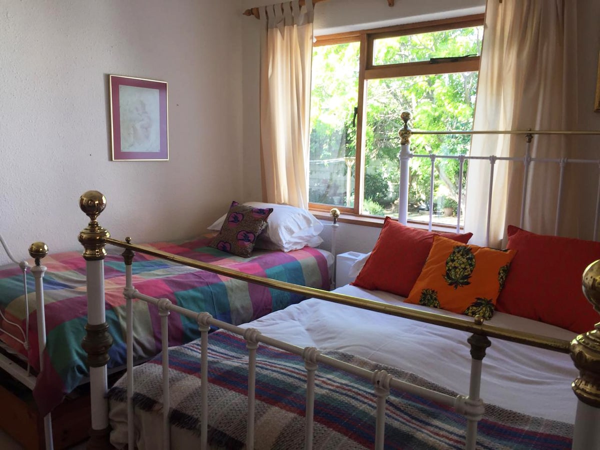 宽敞的卧室，配有一张双人床和一张单人床、书桌和橱柜