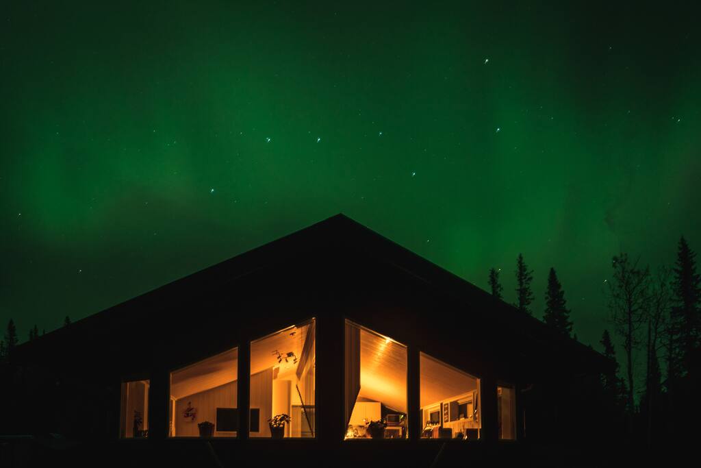 Huset framifrån med norrsken bakom