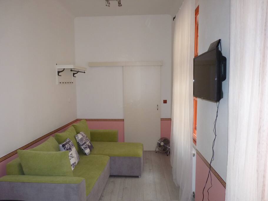 Room with sofa, TV and door leading to the bedroom