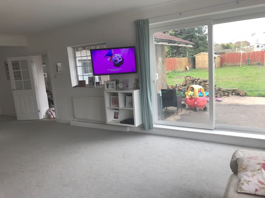 Lounge with wall mounted TV and a garden view