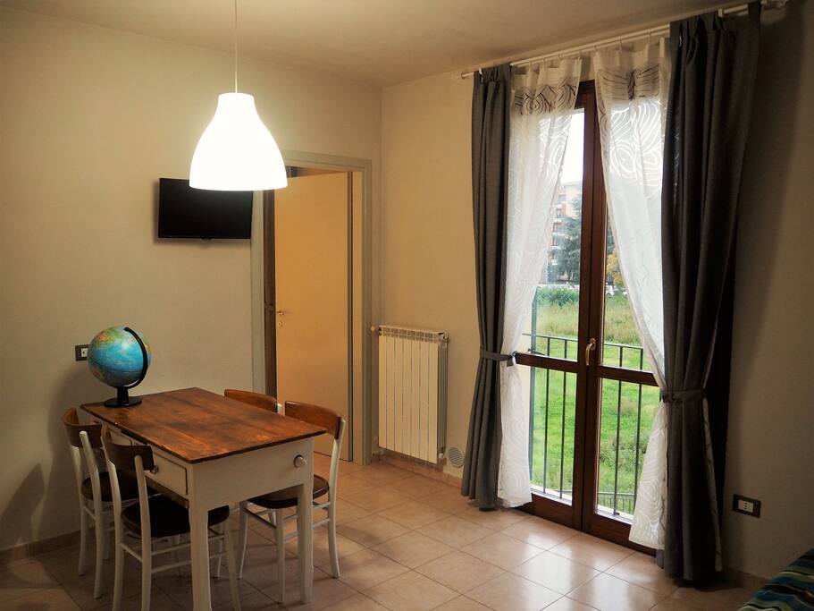 La cucina-soggiorno, con una luminosa porta finestra che da su un'ampia area verde privata. Kitchen & livingroom.