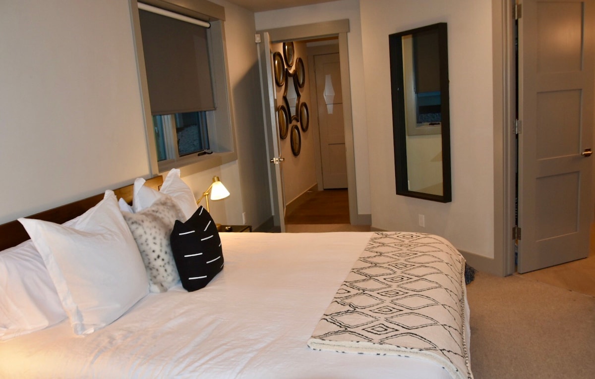 חדר שינה ראשי עם מיטת קינג סייז וחדר רחצה צמוד.