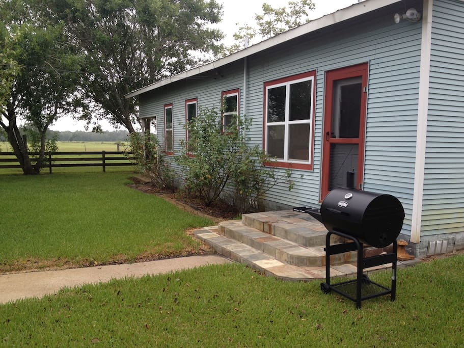 Side view of farmhouse with outdoor grill.