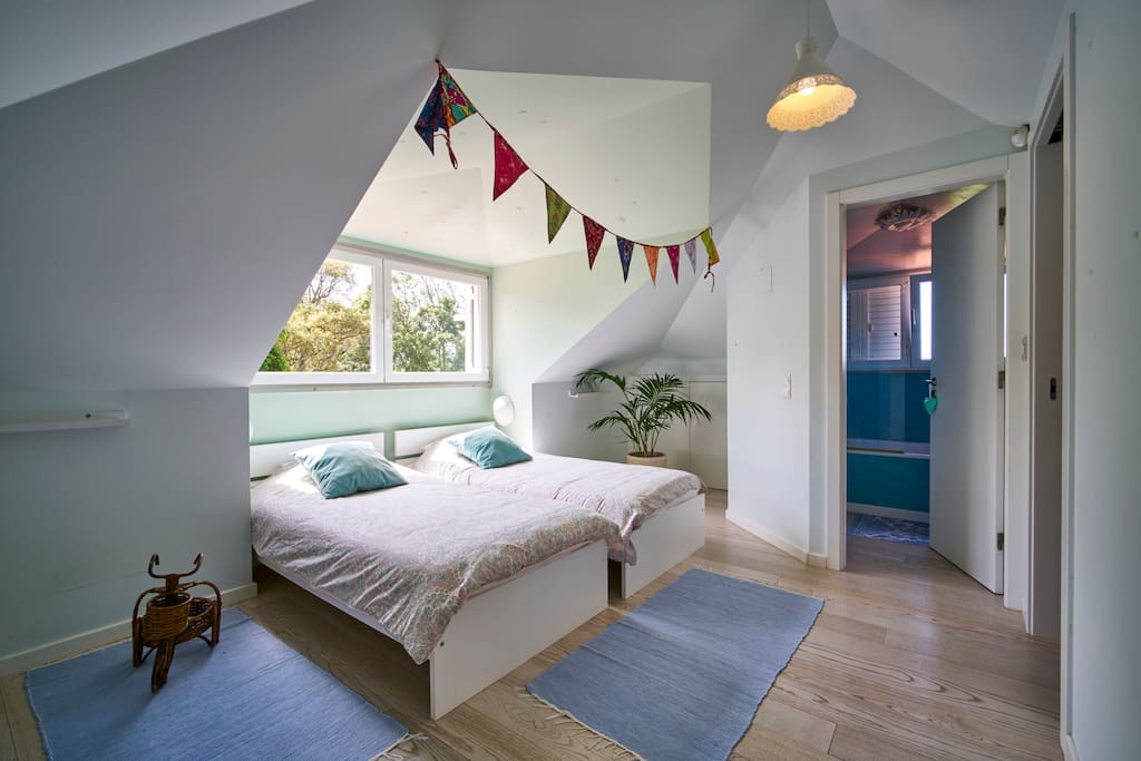 Upstairs room with two single bed and a fully equipped blue bathroom