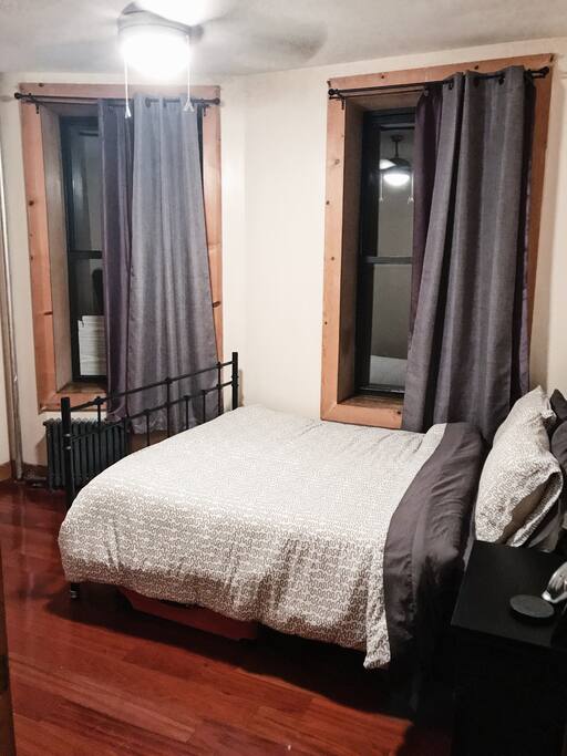 Queen size bed in spacious bedroom. Private room with nightstand and closet.