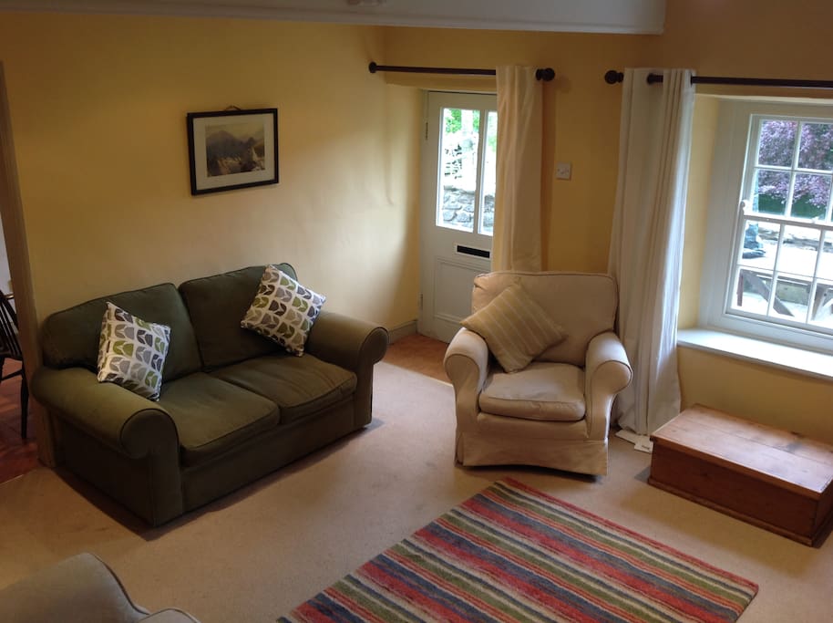 Warm, snug and well decorated sitting room with open fire and door leading out to terrace, lovely view, colour TV and DVD player.