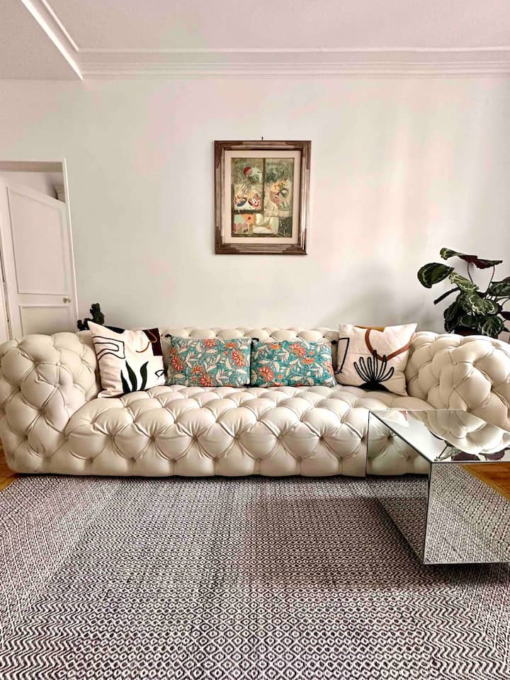 Sebule iliyo na sofa ya ubunifu, meza ya kahawa na zulia karibu na duka la Conran - mchoro unaonyesha kanivali ya Venice