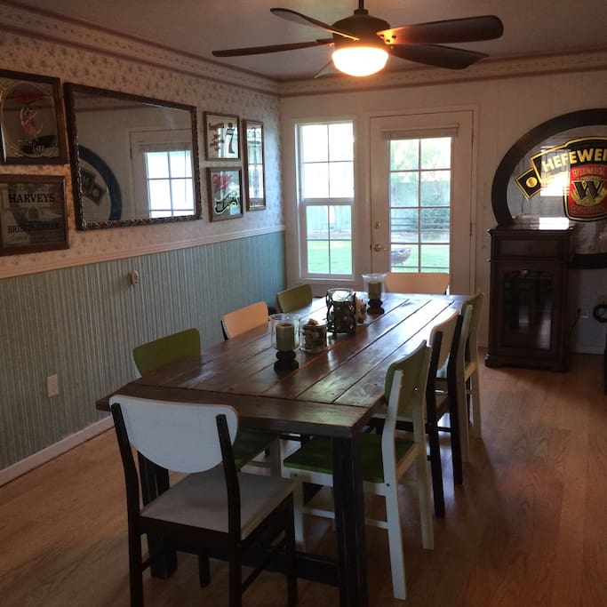Barn table, floral walls, and vintage beer signs give the dining room a fun and cozy country feel.