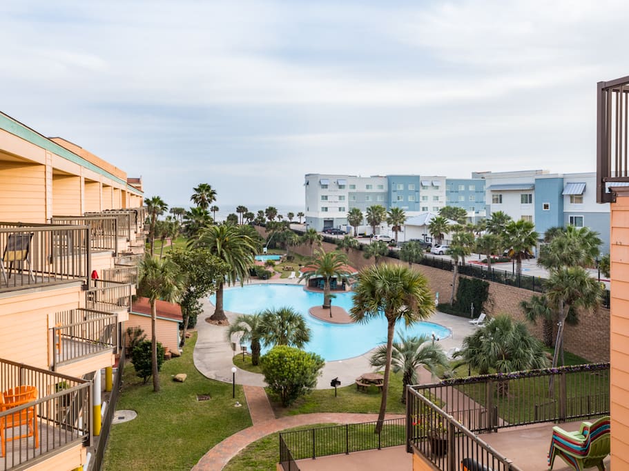 The resort boasts a huge pool with trees and lawn surrounding.