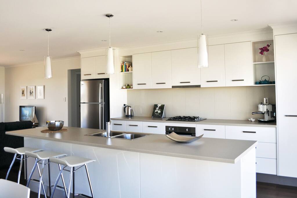 Modern fully equipped kitchen with electric oven and stove top, dishwasher and microwave.