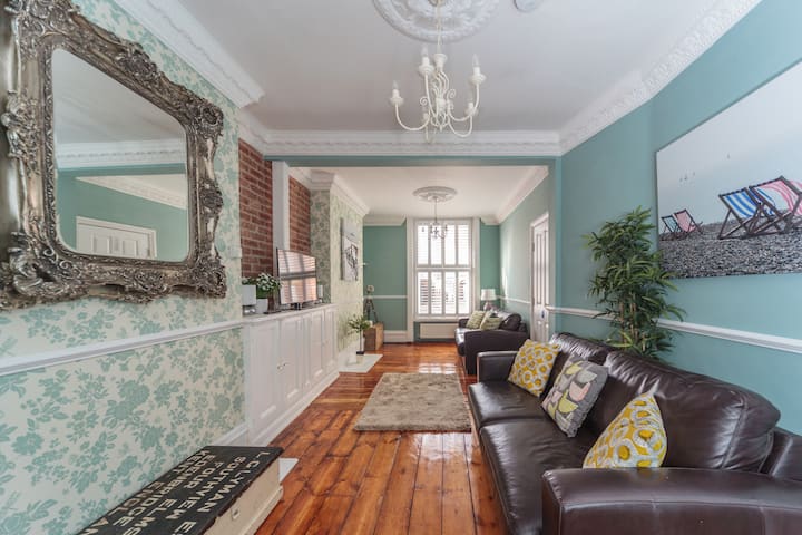 Харесва ни гледката на тази красиво възстановена регентска всекидневна с пясъчен дървен под и капаци на плантации.