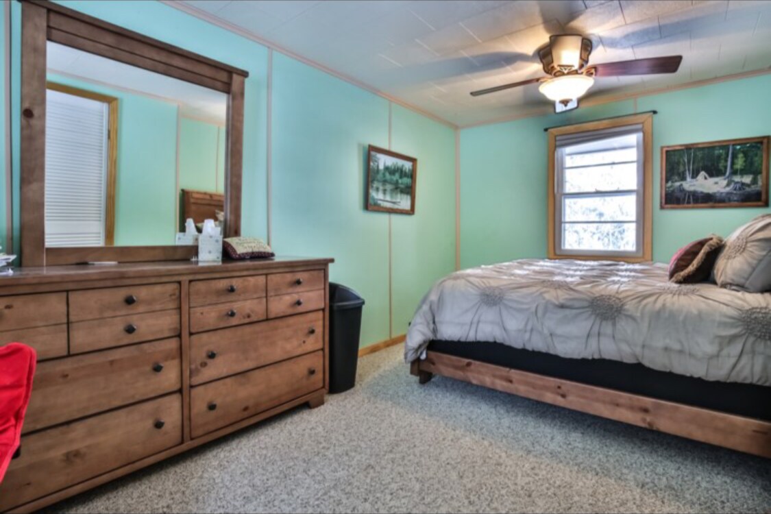 Spálňa s manželskou posteľou a krásnou drevenou komorou. 