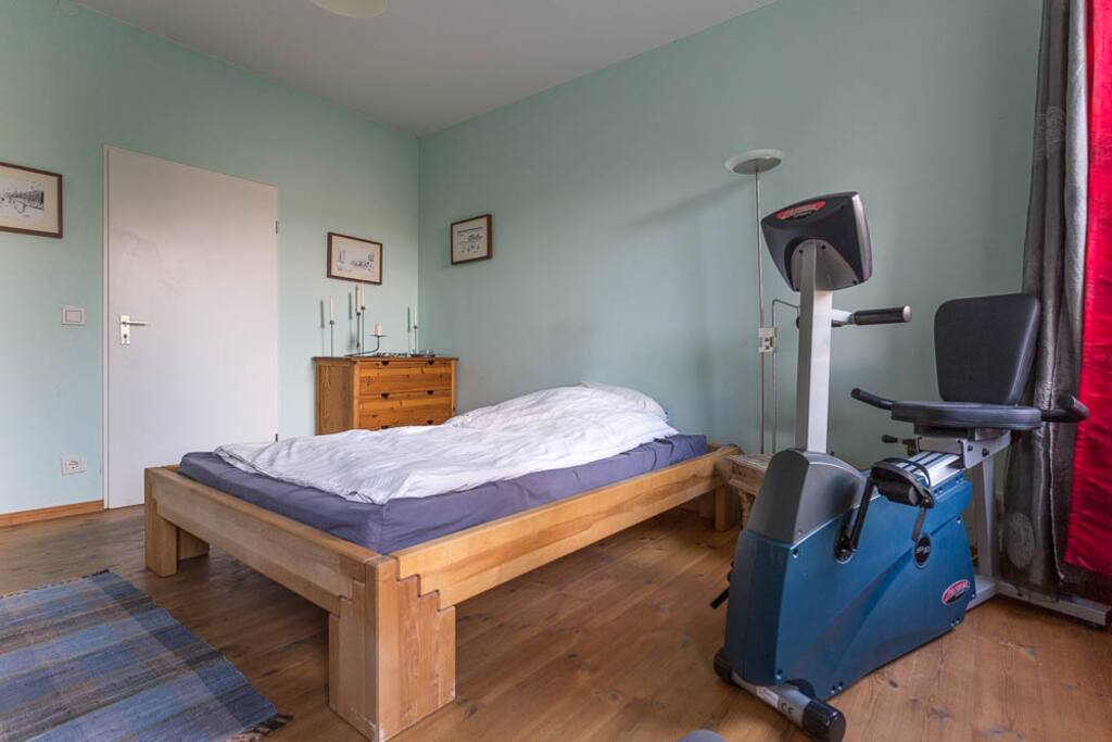 Schlafzimmer mit 140-Bett, Schreibtisch, Fahrradergometer und TV